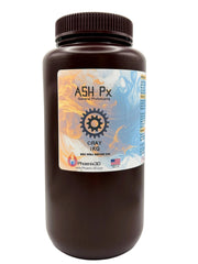 A dark brown plastic bottle of Phoenix 3D Supply Ash Px, General Prototyping (3D printing resin), Gray 1kg, featuring a colorful label with a gear logo, set against a plain white background with the Phoenix 3D logo, a United States flag with the words MADE IN USA, Detroit MI.